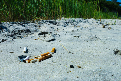 Cigarette Butts in Sand on a Beach